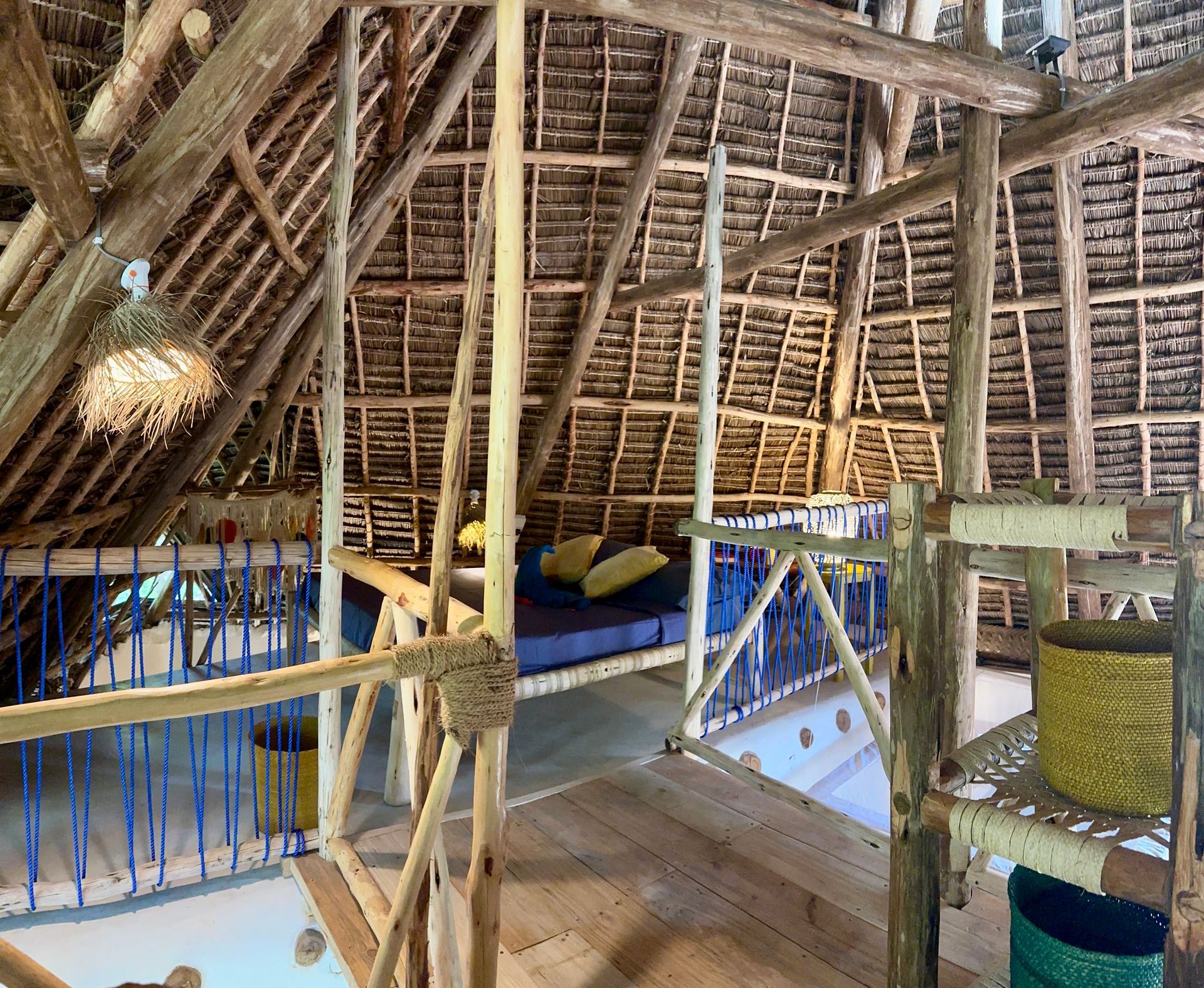 A room with a thatched roof and a wooden floor.