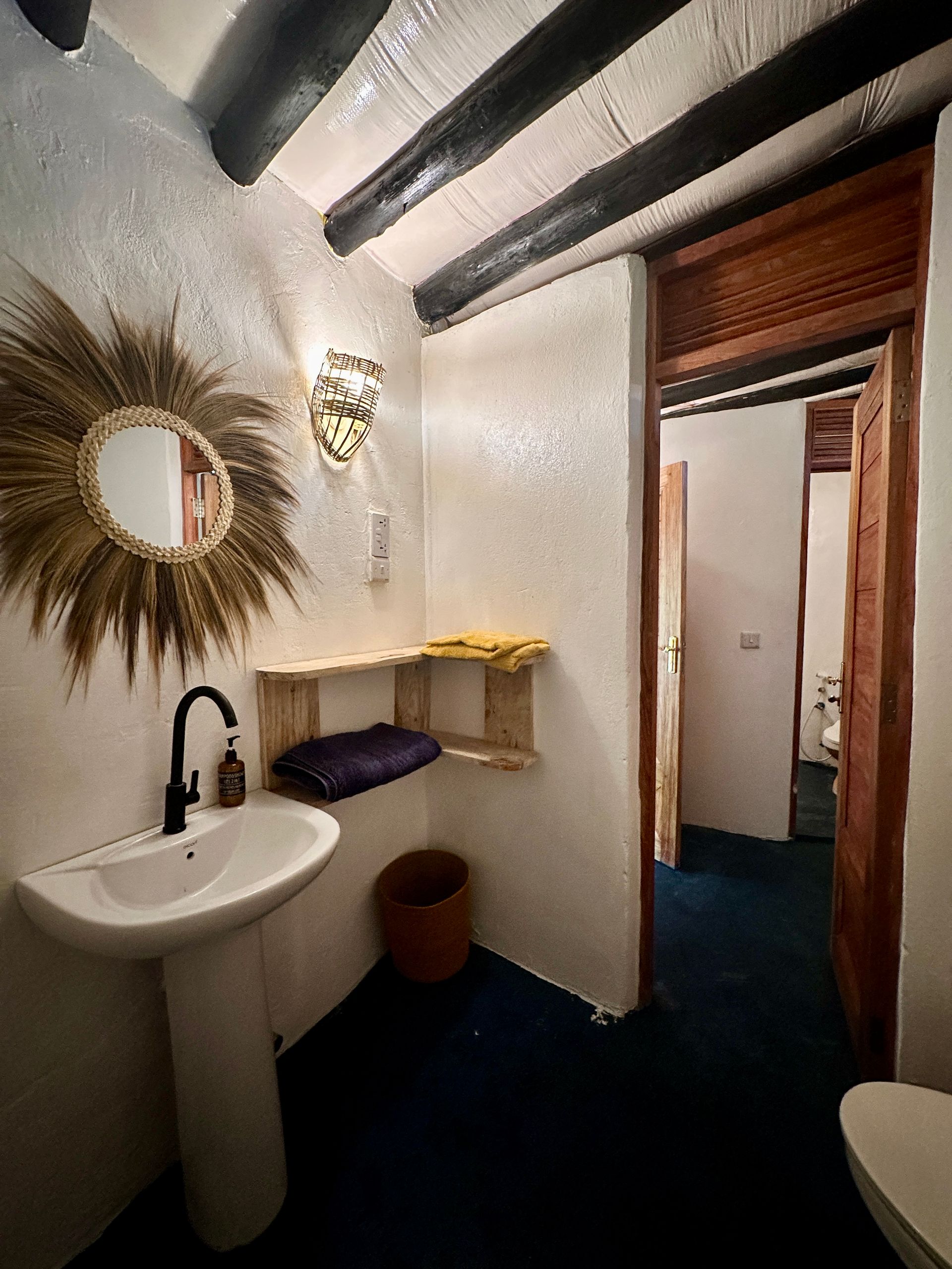 A bathroom with a sink , toilet and mirror.