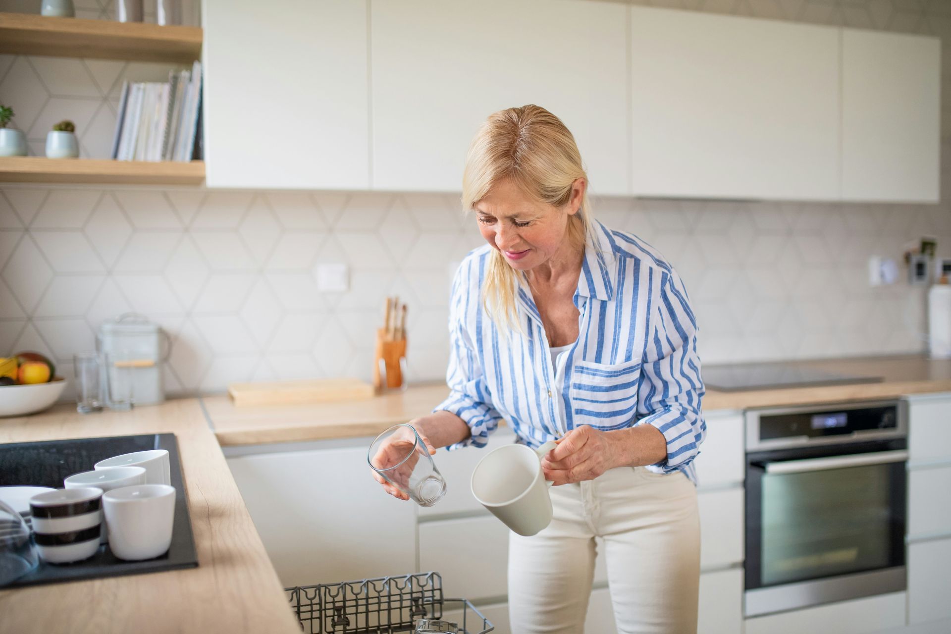 Woman pouring liquid into a pot in a bright modern kitchen