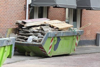 green dumpster with trash