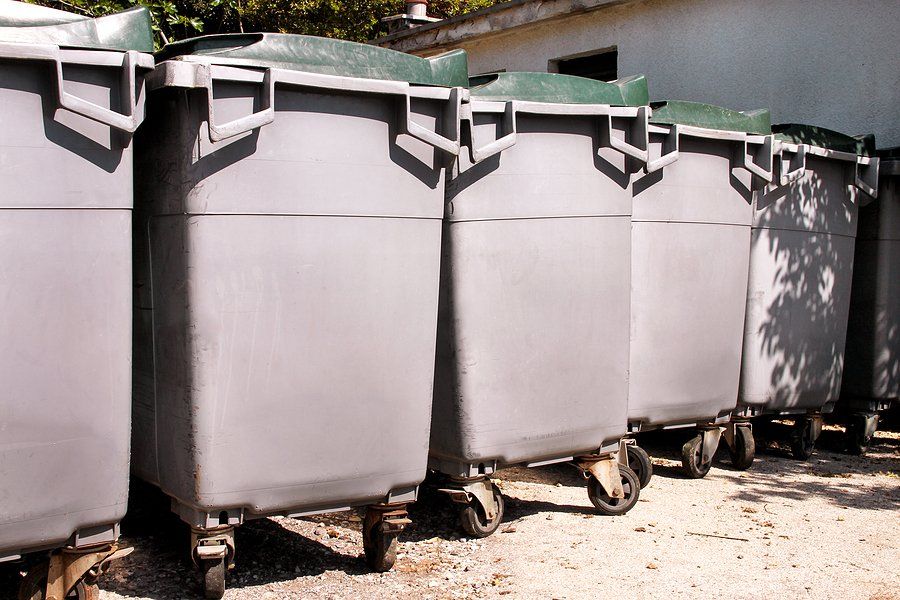 gray garbage dumpsters beside the building