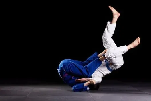 A person is doing a jiu jitsu takedown throw.