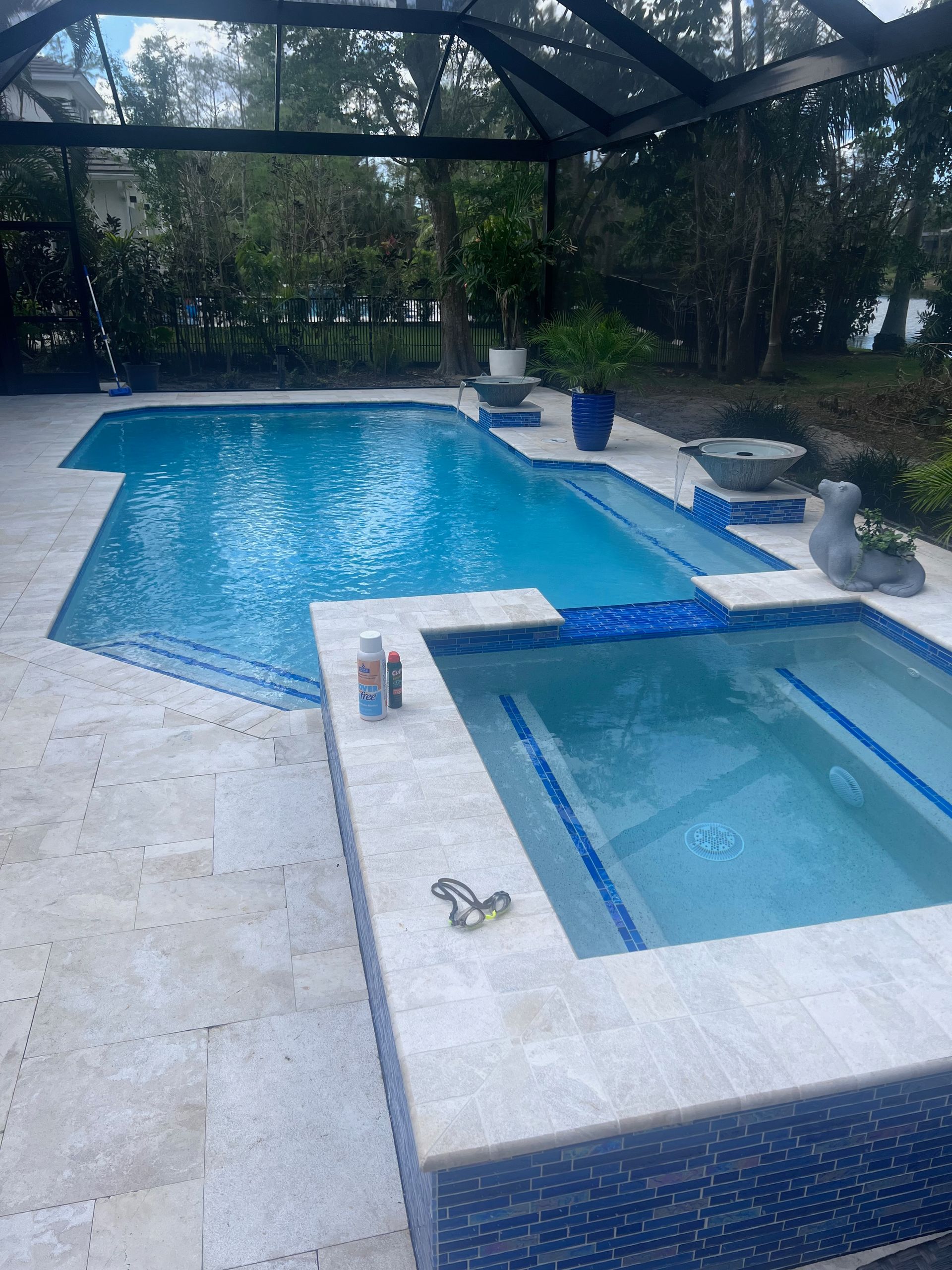 A large swimming pool with a hot tub next to it.