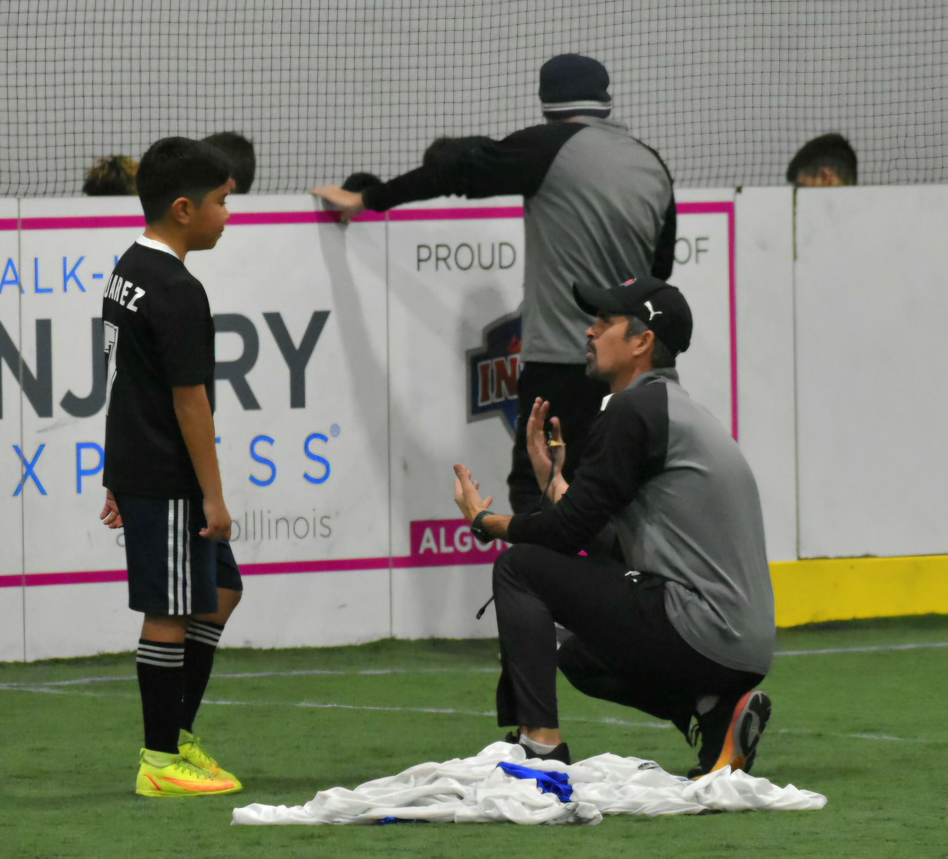 Youth soccer player listens to coach on the field.