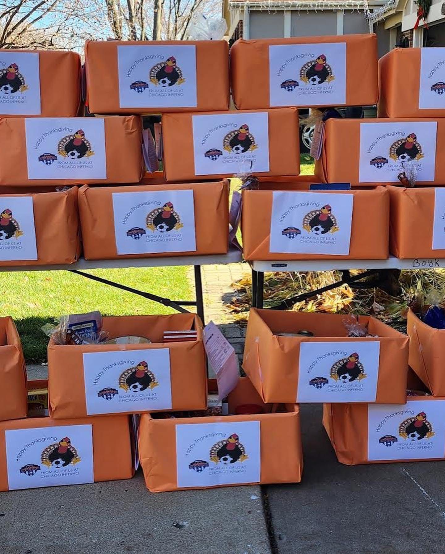 Orange boxes stacked with labels, likely for a giveaway or donation event, outdoors.