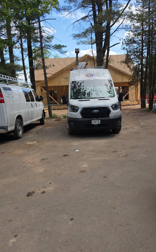 Pro Tech air solution van parked on a dirt drive in front of a tan building among tall pine trees.
