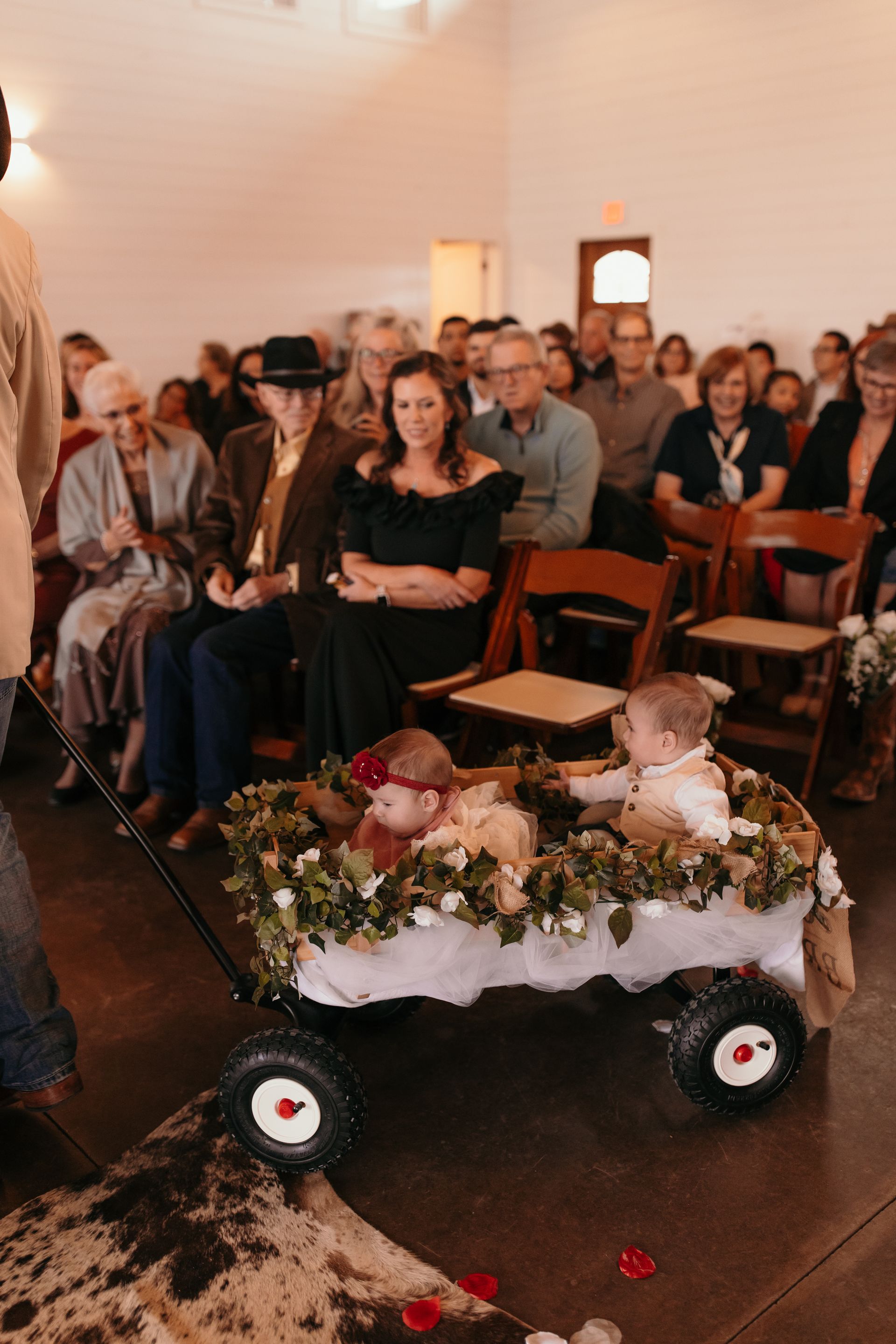 toddlers pulled down aisle in wagon during wedding