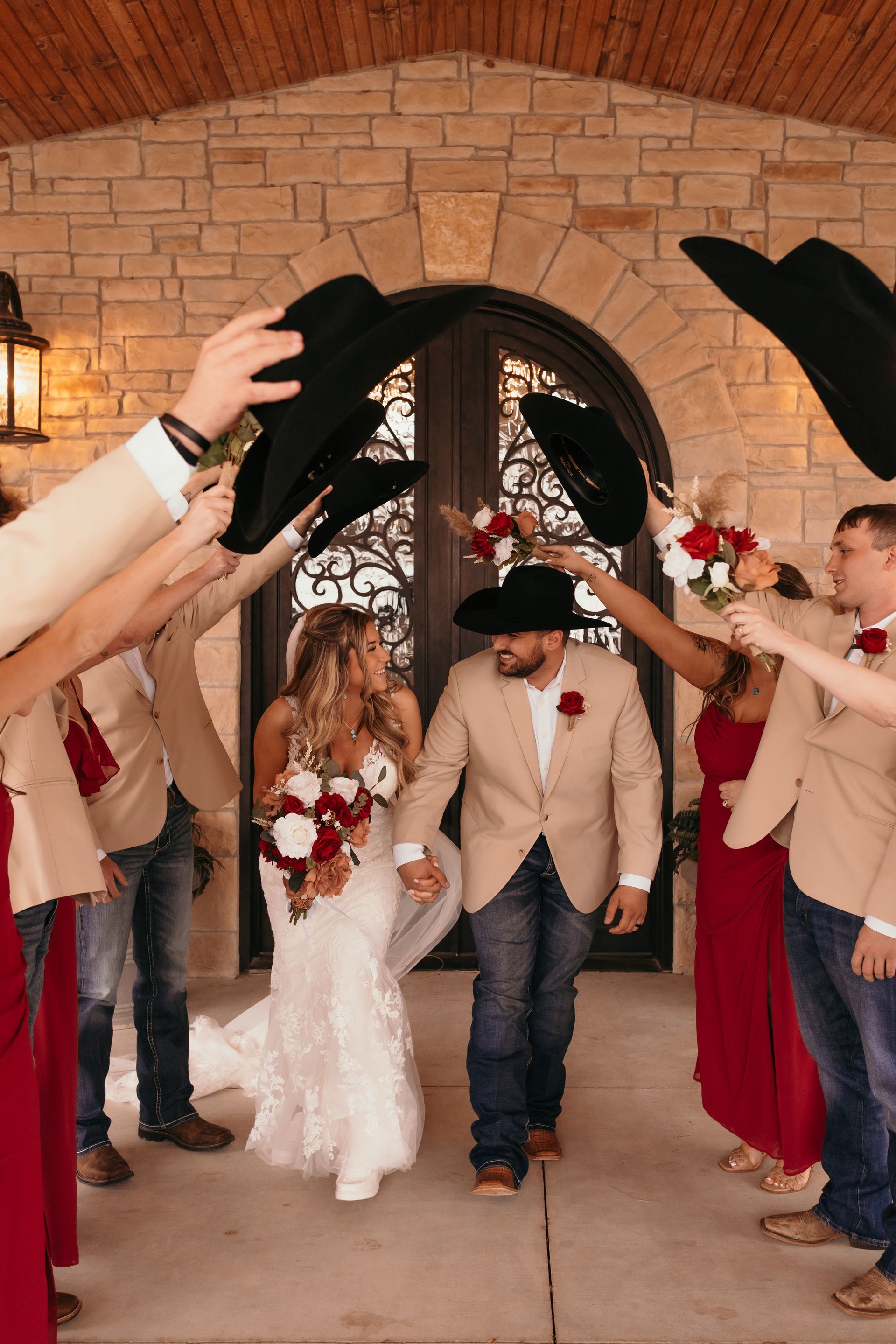 bride and groom walking between wedding party's raised arms