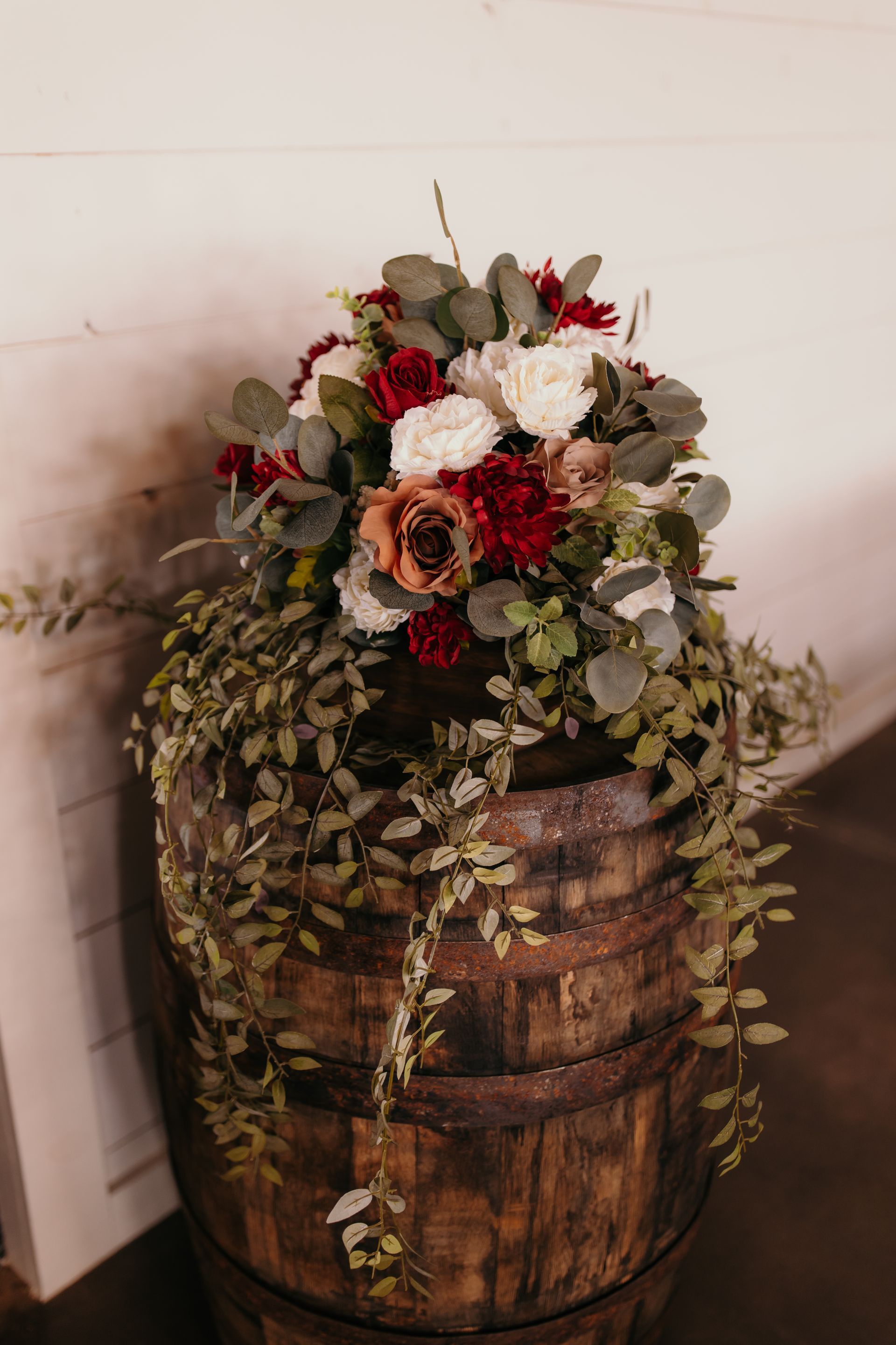 fall toned wedding flowers on whiskey barrel