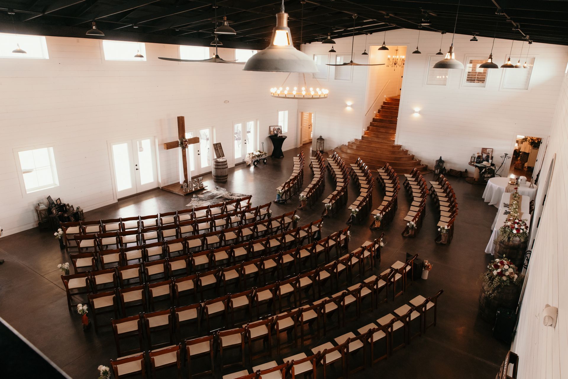 indoor wedding ceremony at wild wood wood wedding and event center with large cross altar