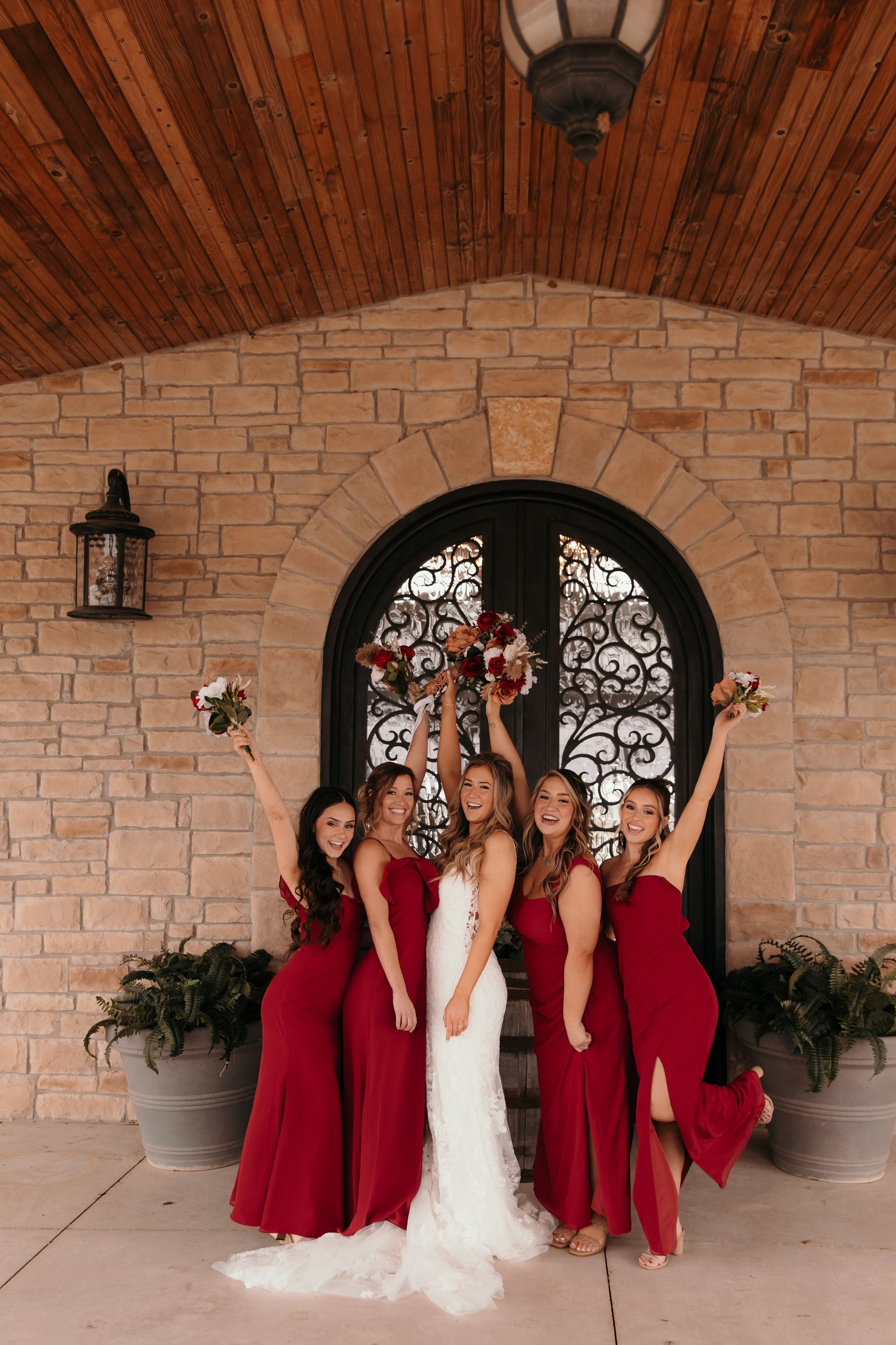bride and bridesmaids posing on wild wood wedding and event center porch