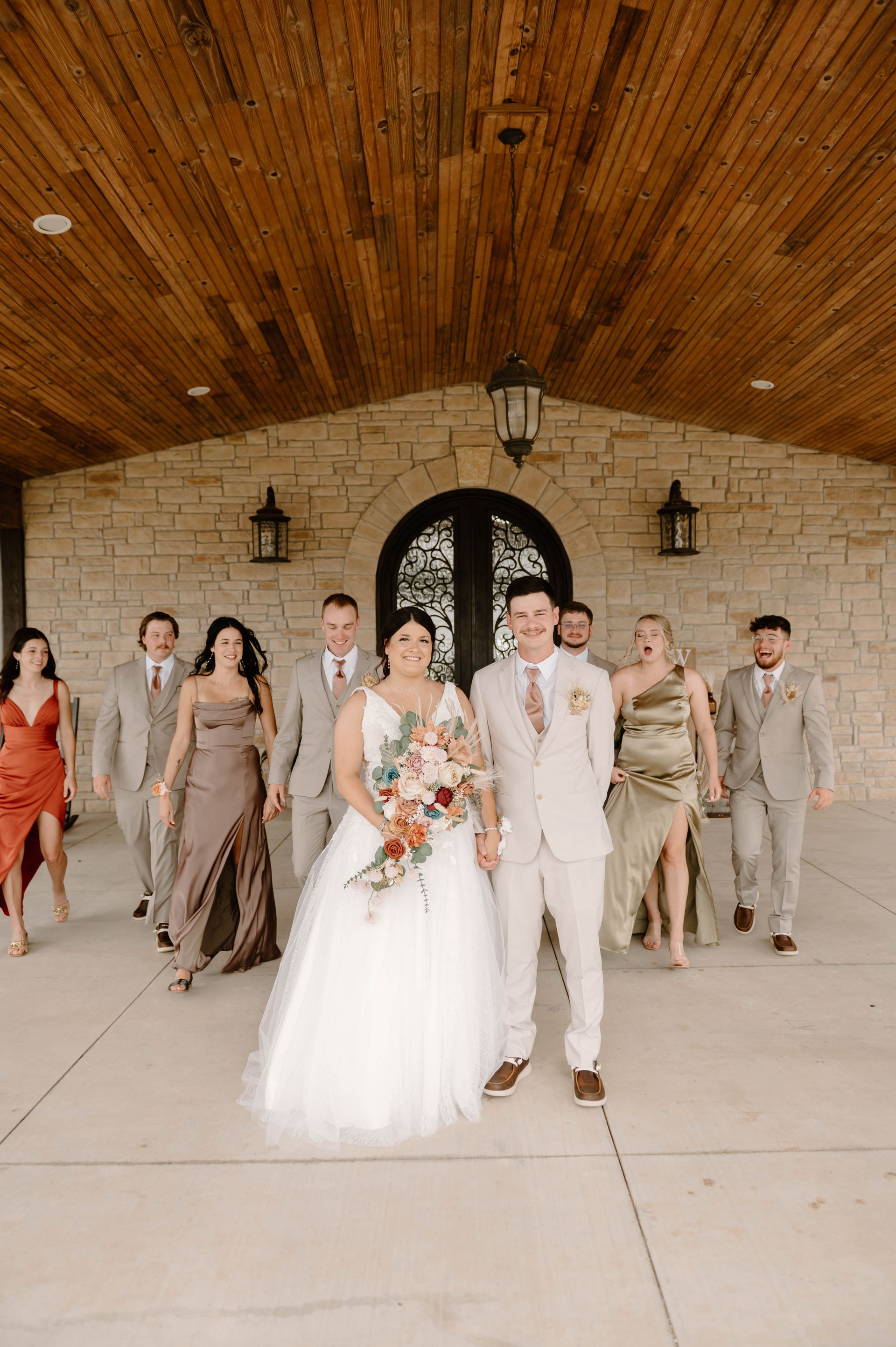 bride and groom with wedding party on venue porch