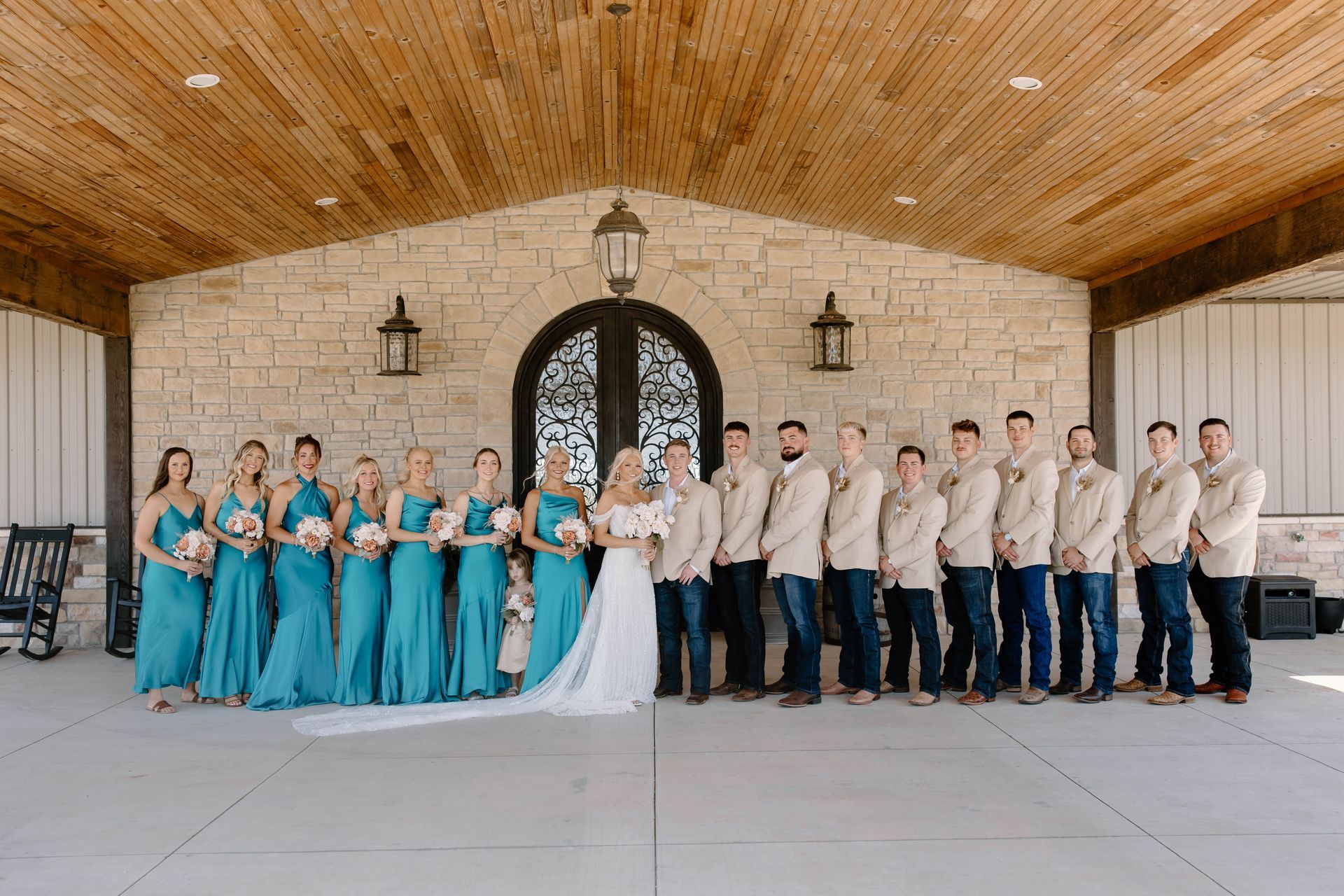bride and groom with wedding party on wild wood wedding and event center porch