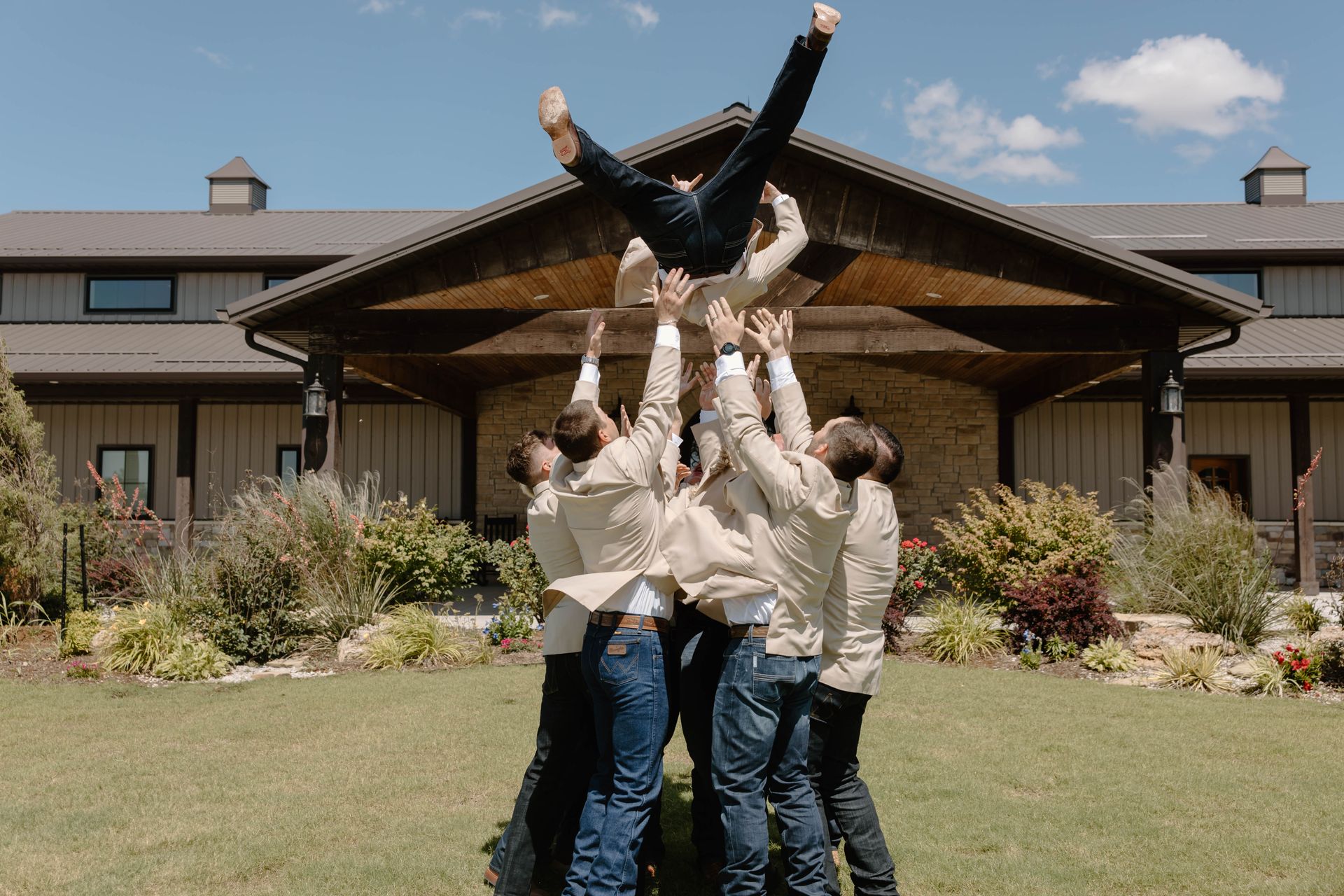 groomsmen tossing groom in the air
