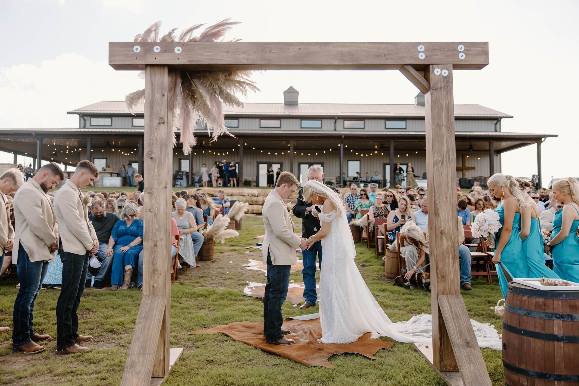 bride and groom praying during outdoor wedding ceremony