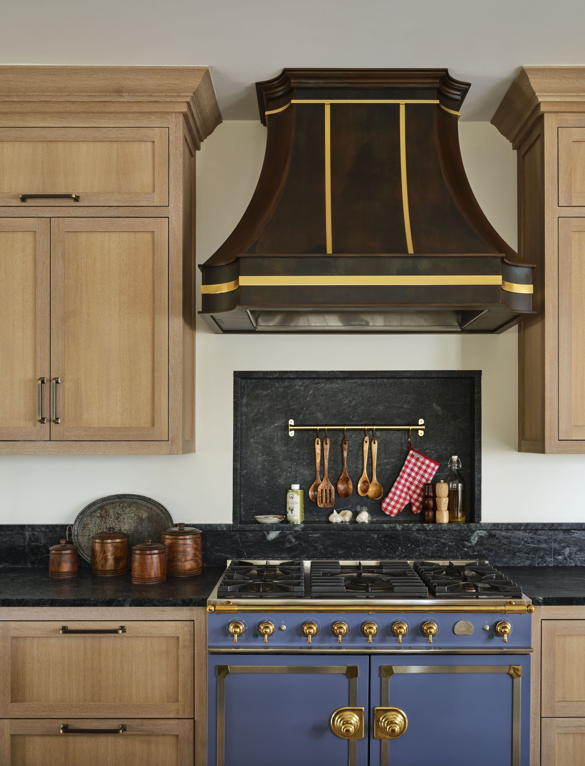A kitchen with a blue stove and wooden cabinets