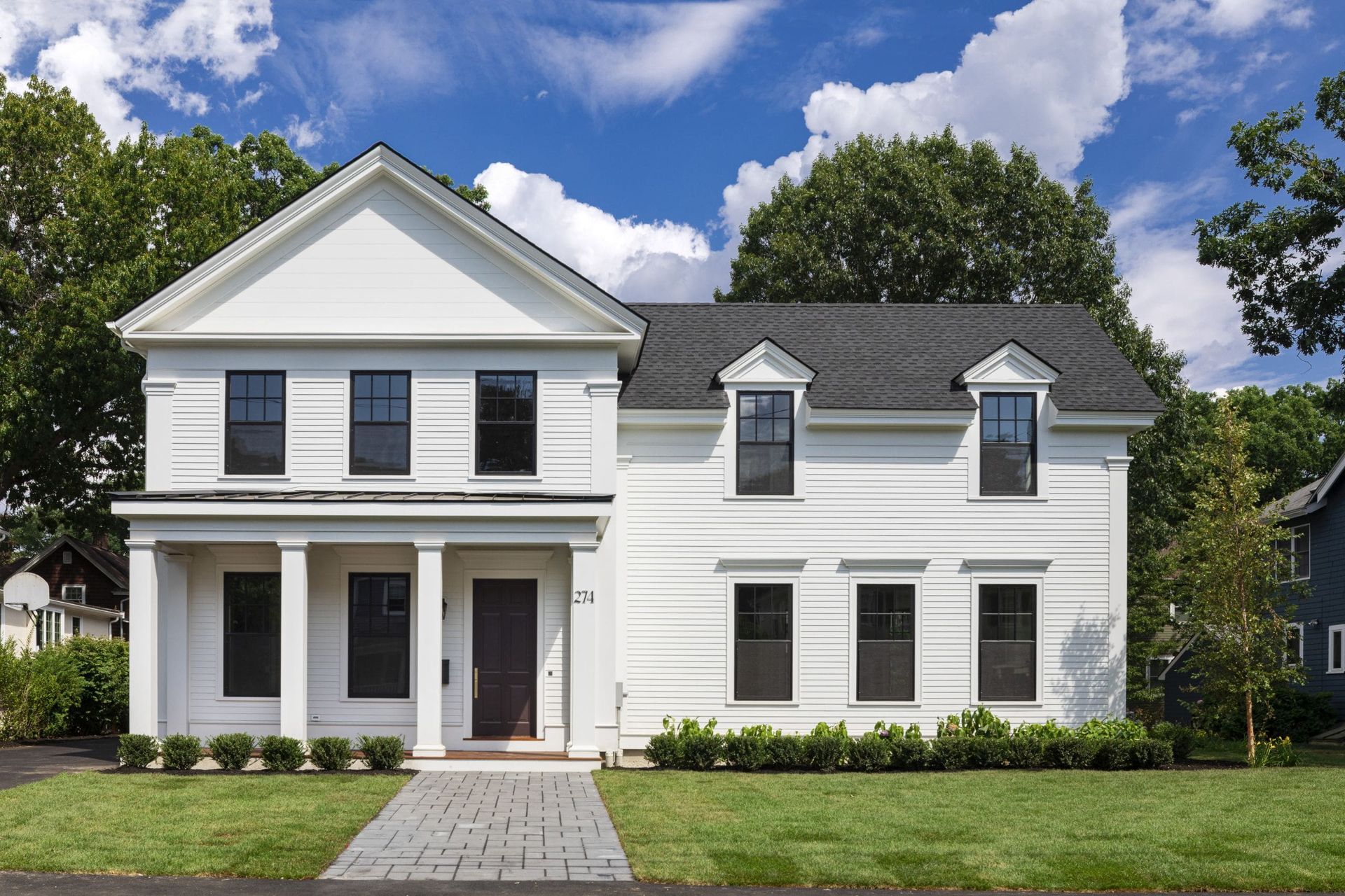 A white house with black windows and a black roof