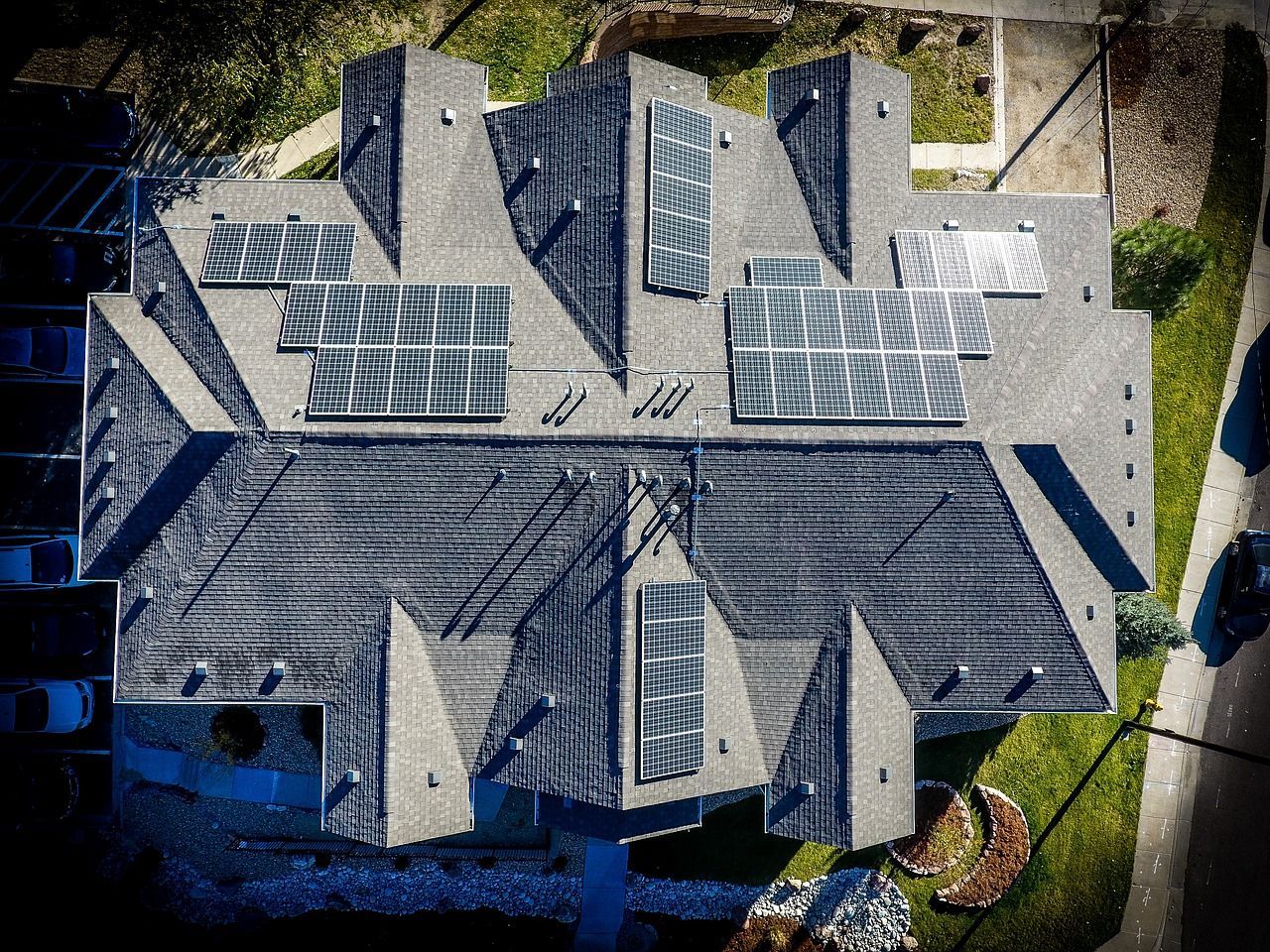 An aerial view of a house with solar panels on the roof.