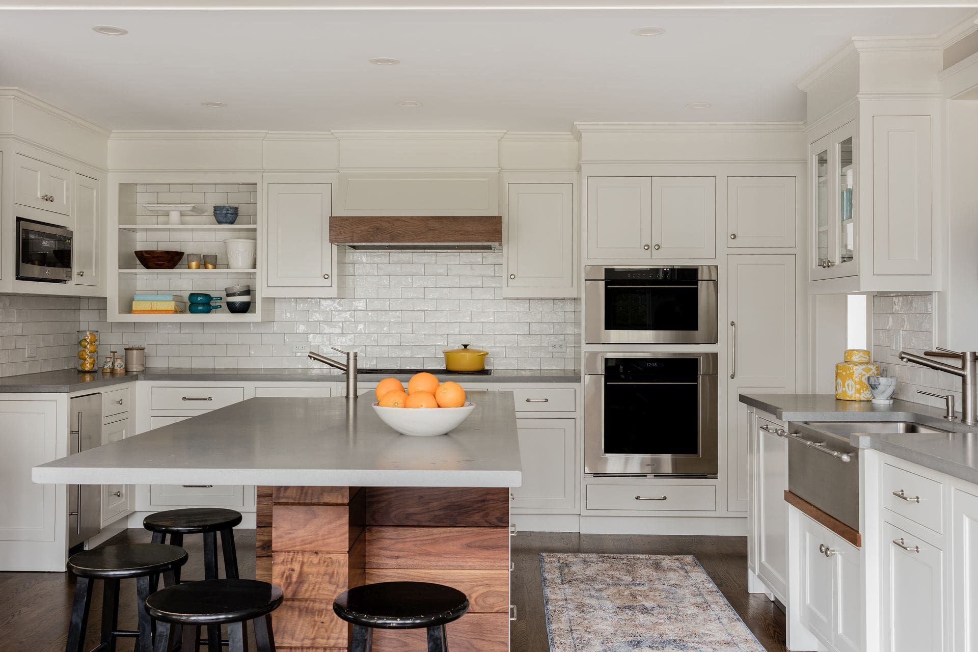A white Hawthorn Builders kitchen with a wood island base, subway-tile backsplash, and built-in doub