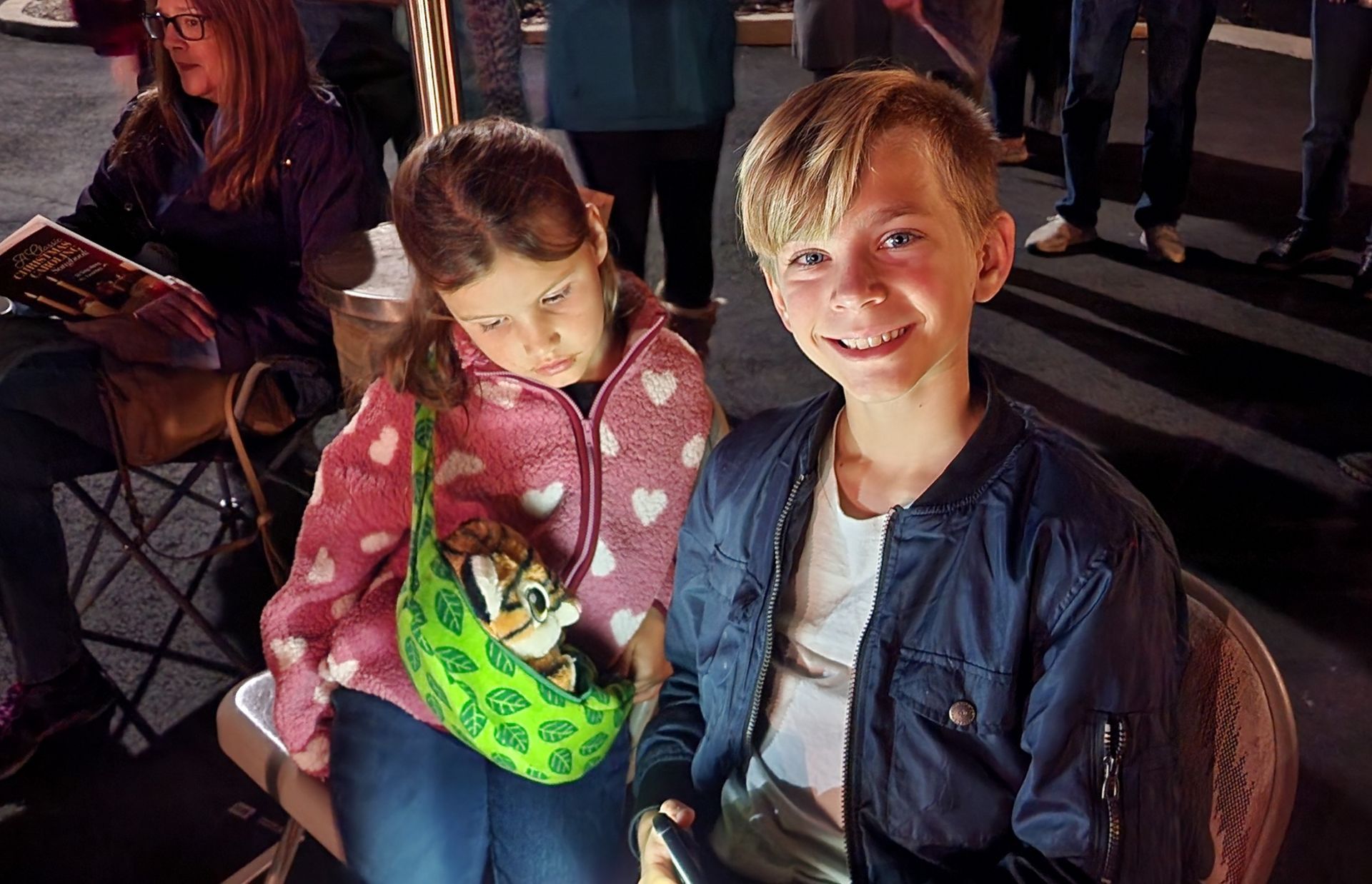 A boy and a girl are sitting next to each other in a chair.