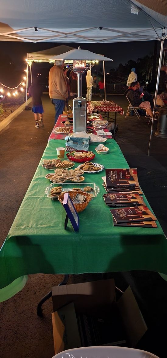 A long table with plates of food on it under a tent.