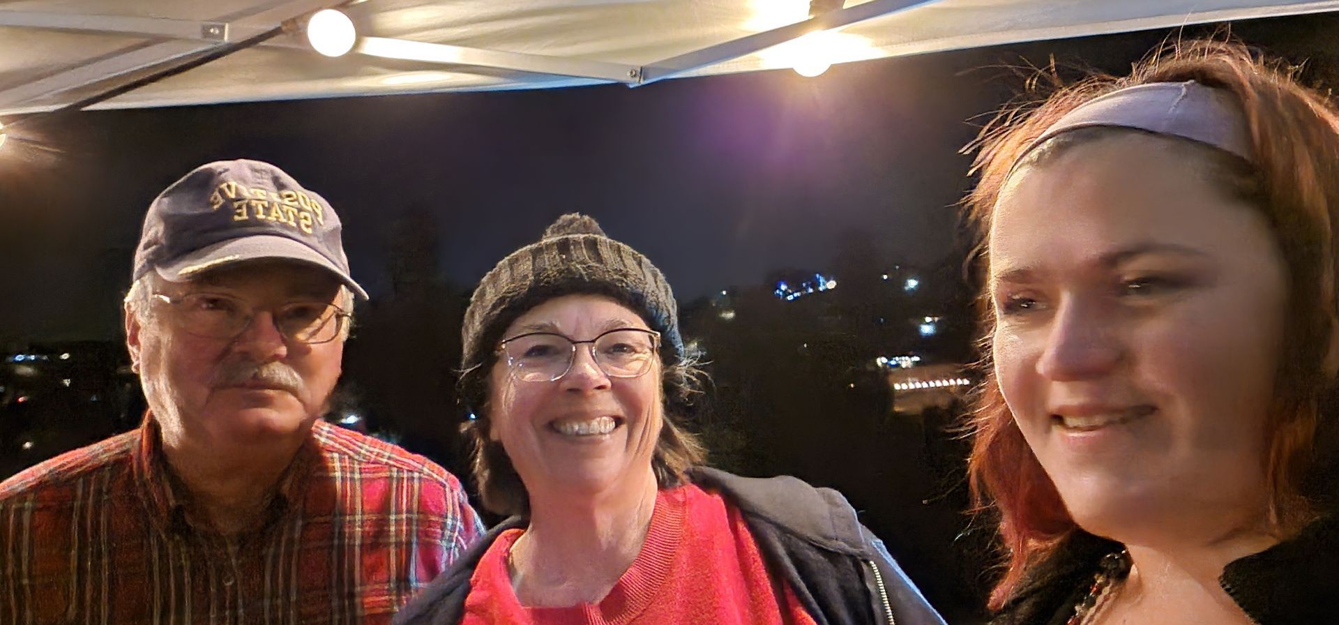 A man and two women are standing next to each other and smiling.
