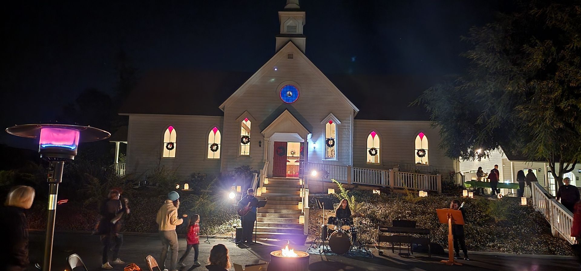 A group of people are standing in front of a church at night.