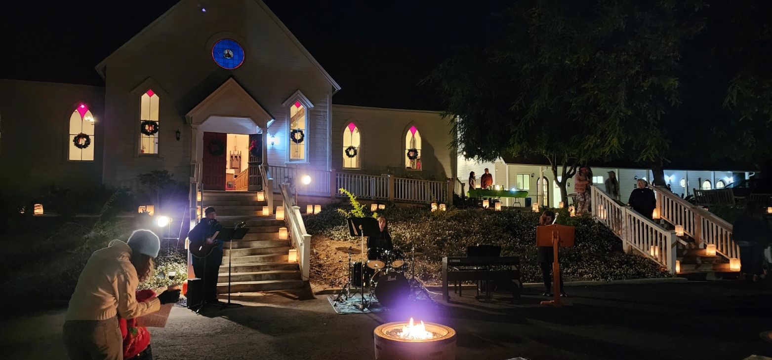 A group of people are standing in front of a church at night.
