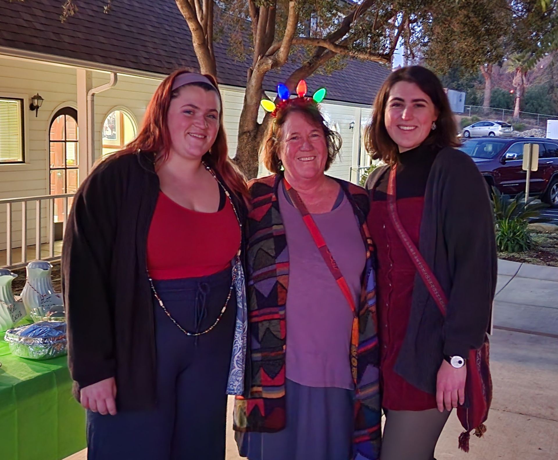 Three women are posing for a picture in front of a building.