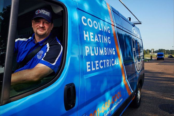 Man in blue shirt, inside a blue van, promoting cooling, heating, plumbing and electrical services.
