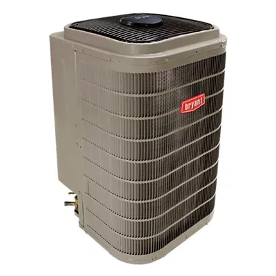 Bryant air conditioner unit with metal fins, beige casing, and a black top; outdoors.