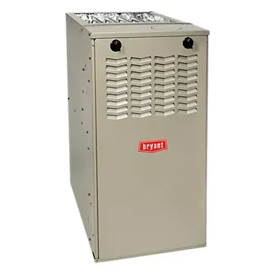 Tan Bryant brand furnace. Metal cabinet with vent and controls, inside a building.
