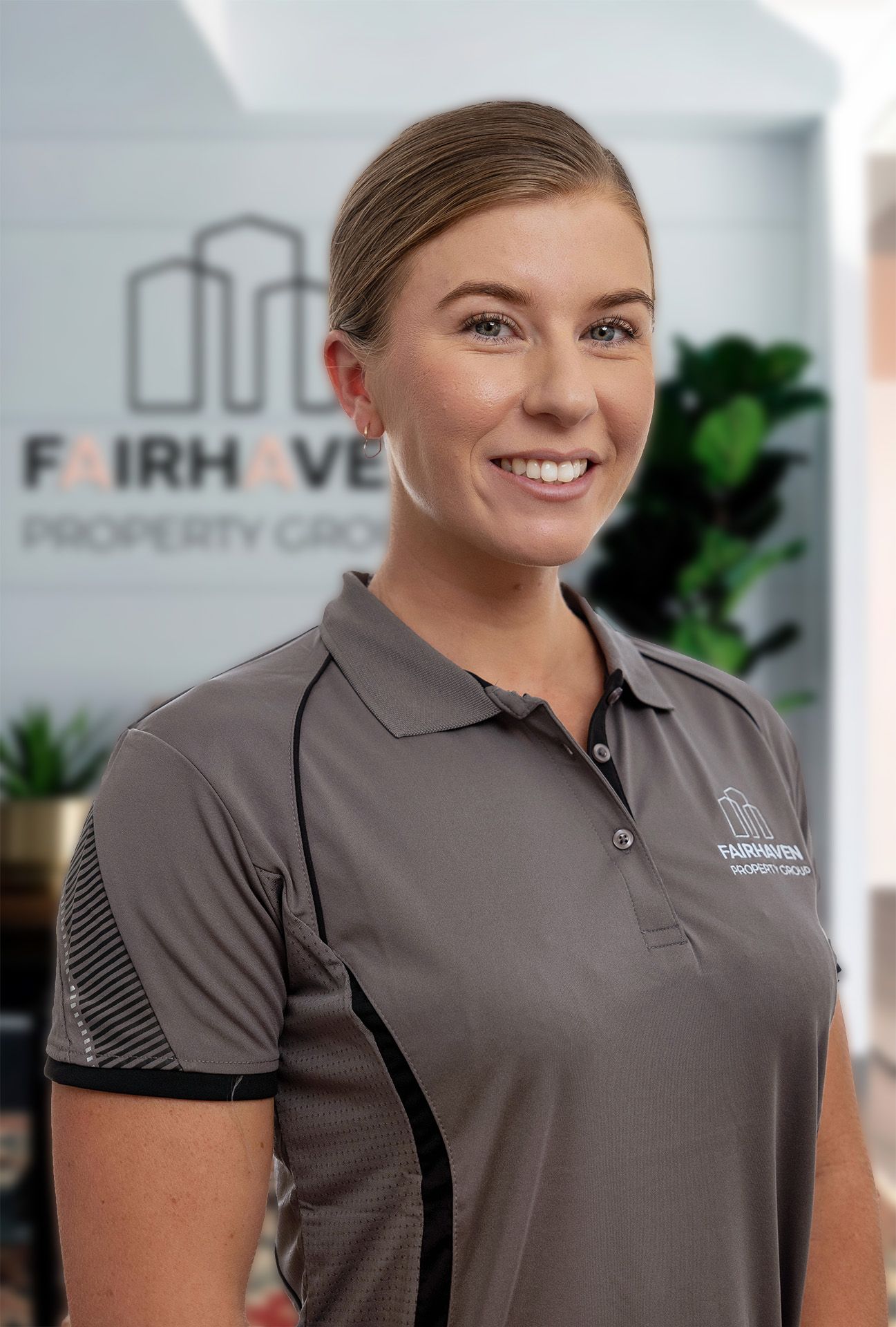 Woman in grey polo shirt smiling, Fairhaven Property Group logo visible.