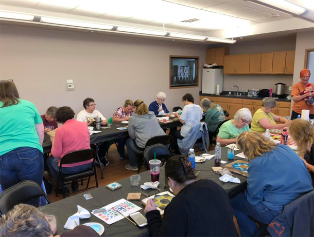 A group of people are sitting around tables in a room