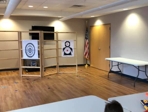 A room with a table and a target with the number 8 on it