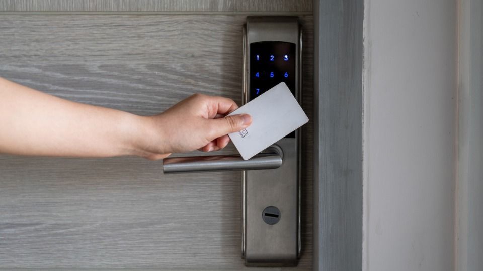 A person is inserting a card into a door lock.