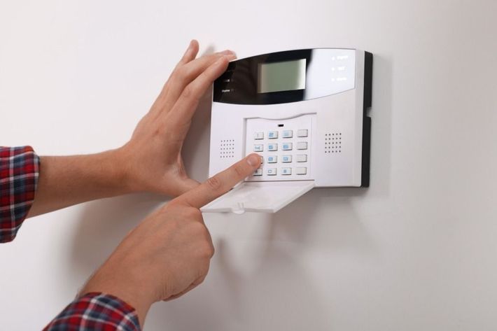 A person is pressing a button on a security system.