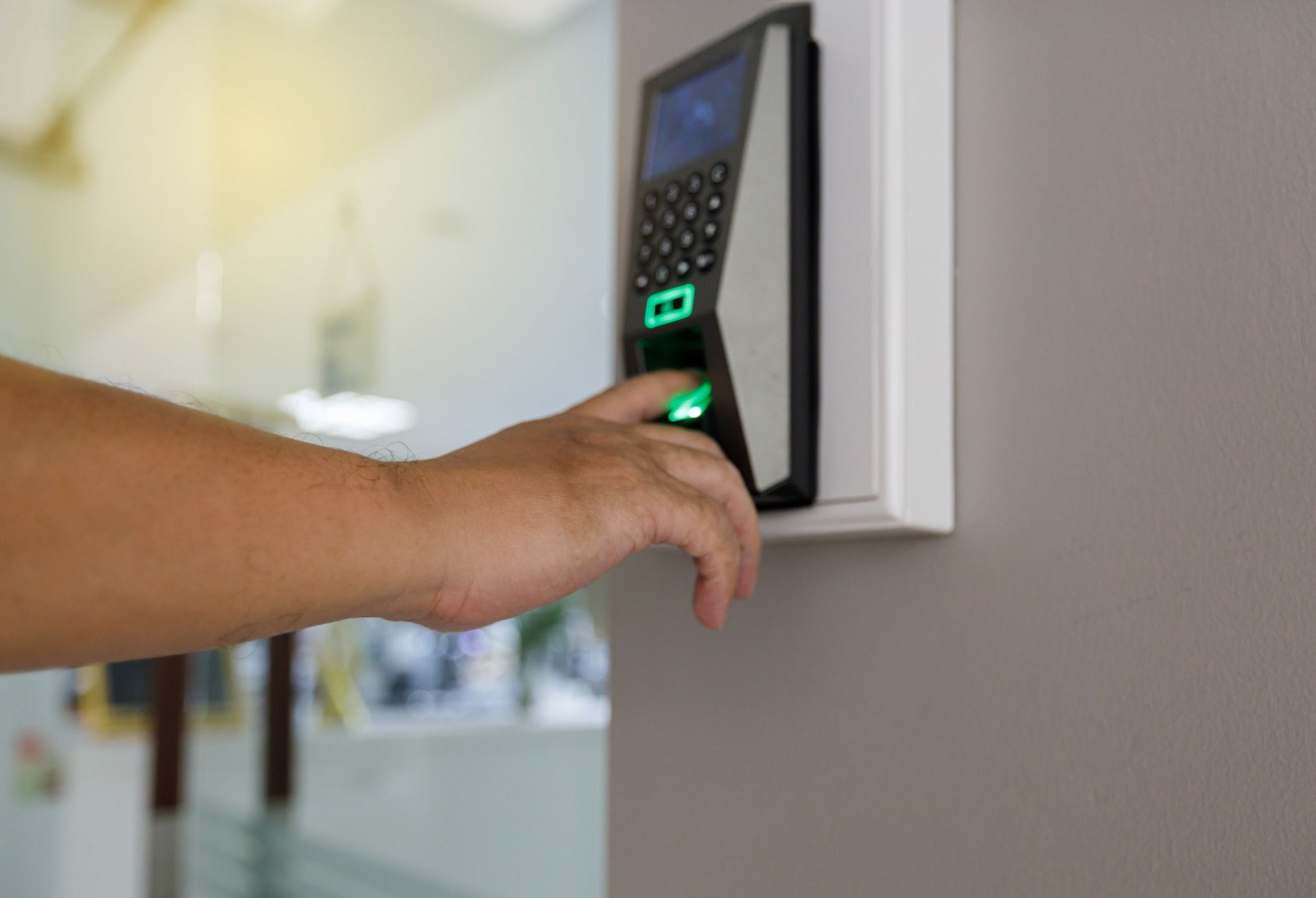 a person is using a fingerprint scanner to enter a building.