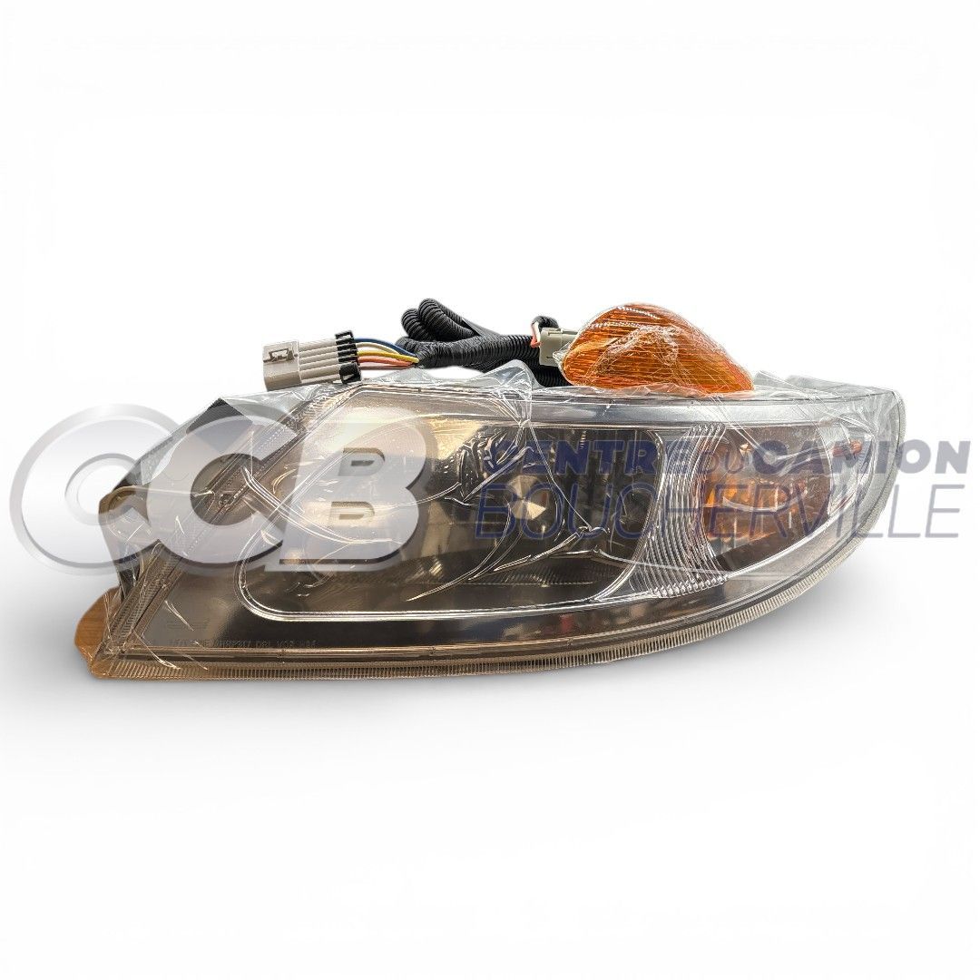 Un bloc optique de phare de moto transparent avec clignotant orange intégré, sur fond blanc uni.