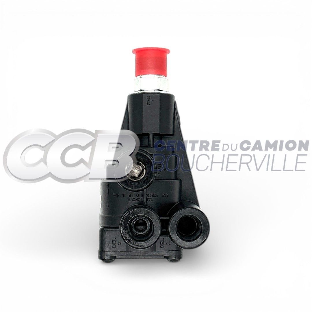 Une valve de frein pneumatique noire avec un petit bouchon rouge sur le dessus, sur fond blanc.