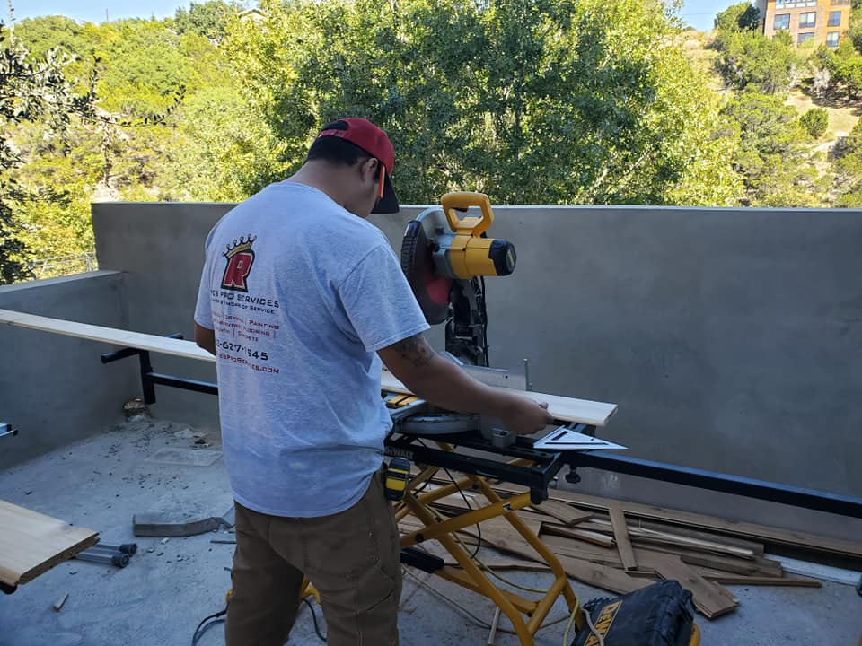 A man is using a circular saw to cut a piece of wood.