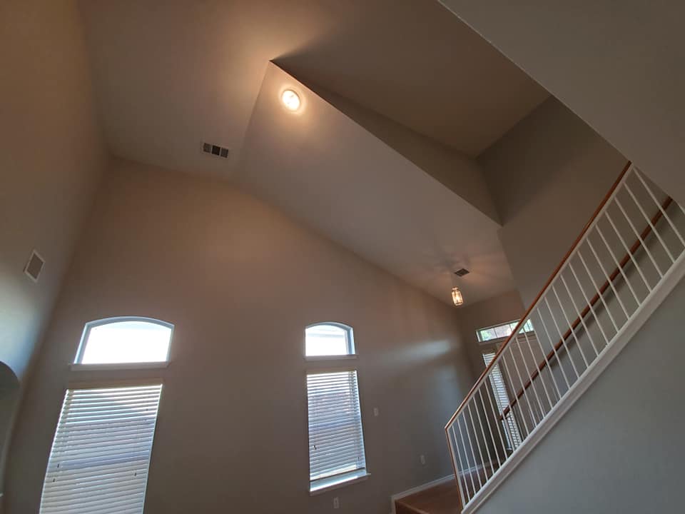 A living room with stairs and a vaulted ceiling