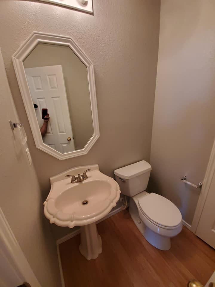 A bathroom with a sink , toilet and mirror.