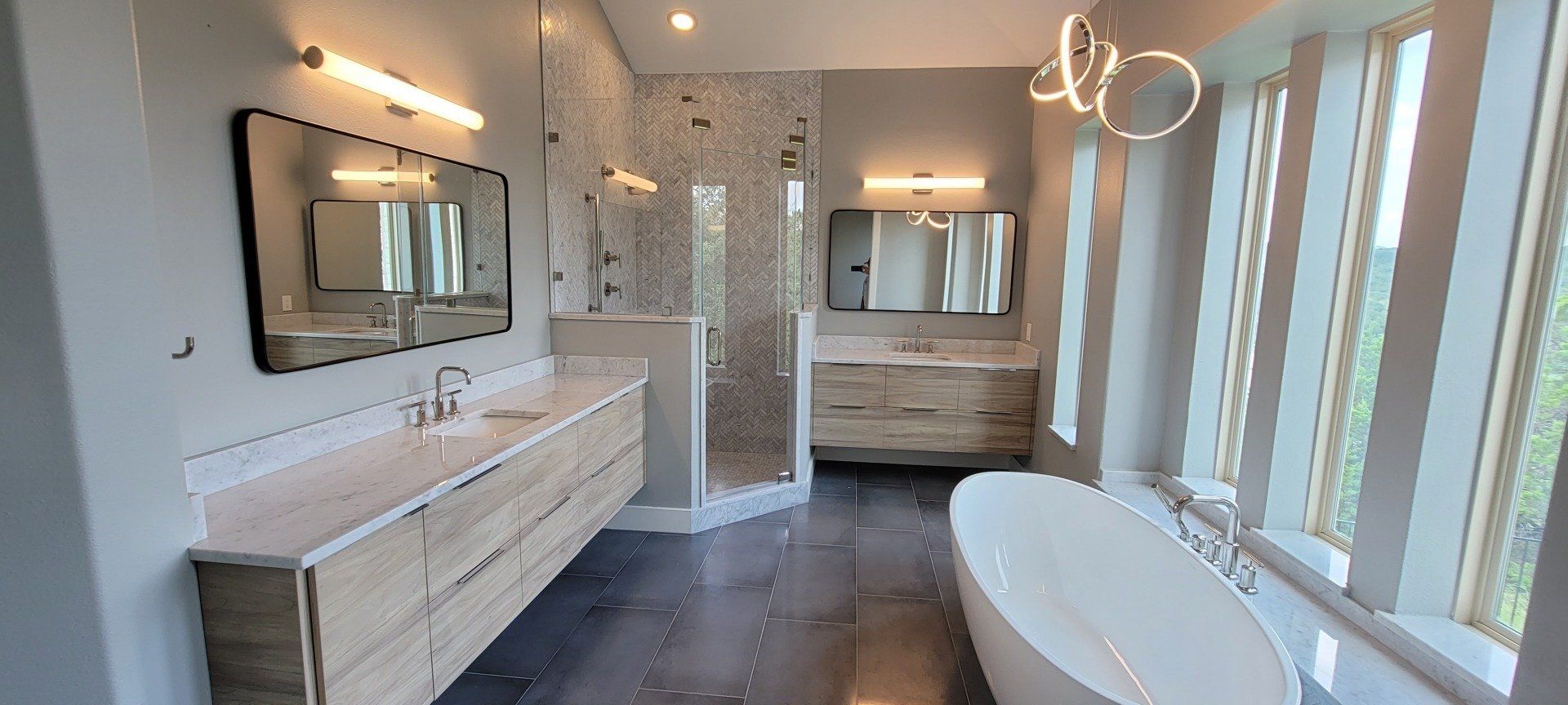 A bathroom with two sinks , a tub , and a shower.