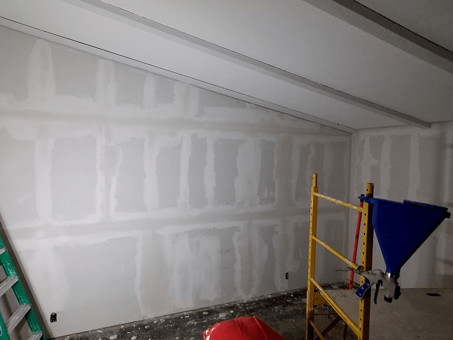 A room with a ladder and scaffolding in it is being remodeled.