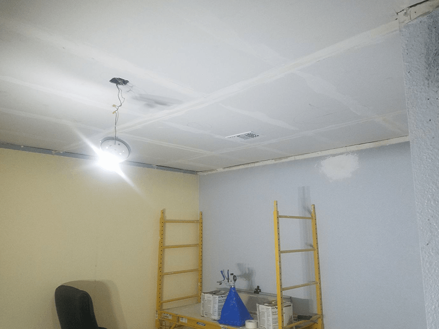 A room with a ladder and a light on the ceiling.