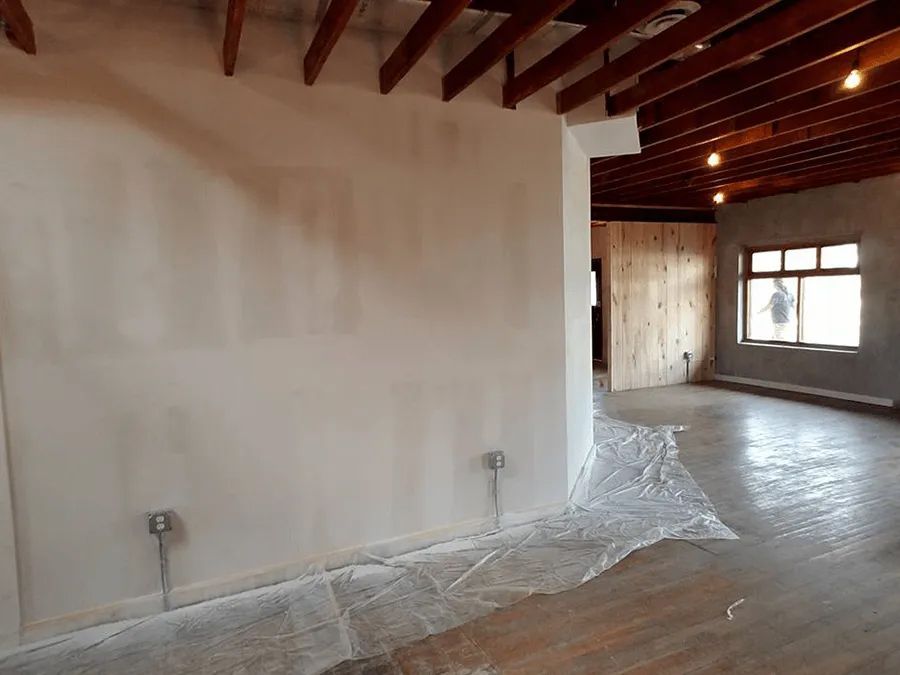 An empty room with a wooden ceiling and a white wall.
