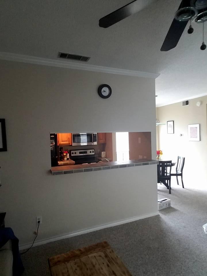 A living room with a ceiling fan and a clock on the wall