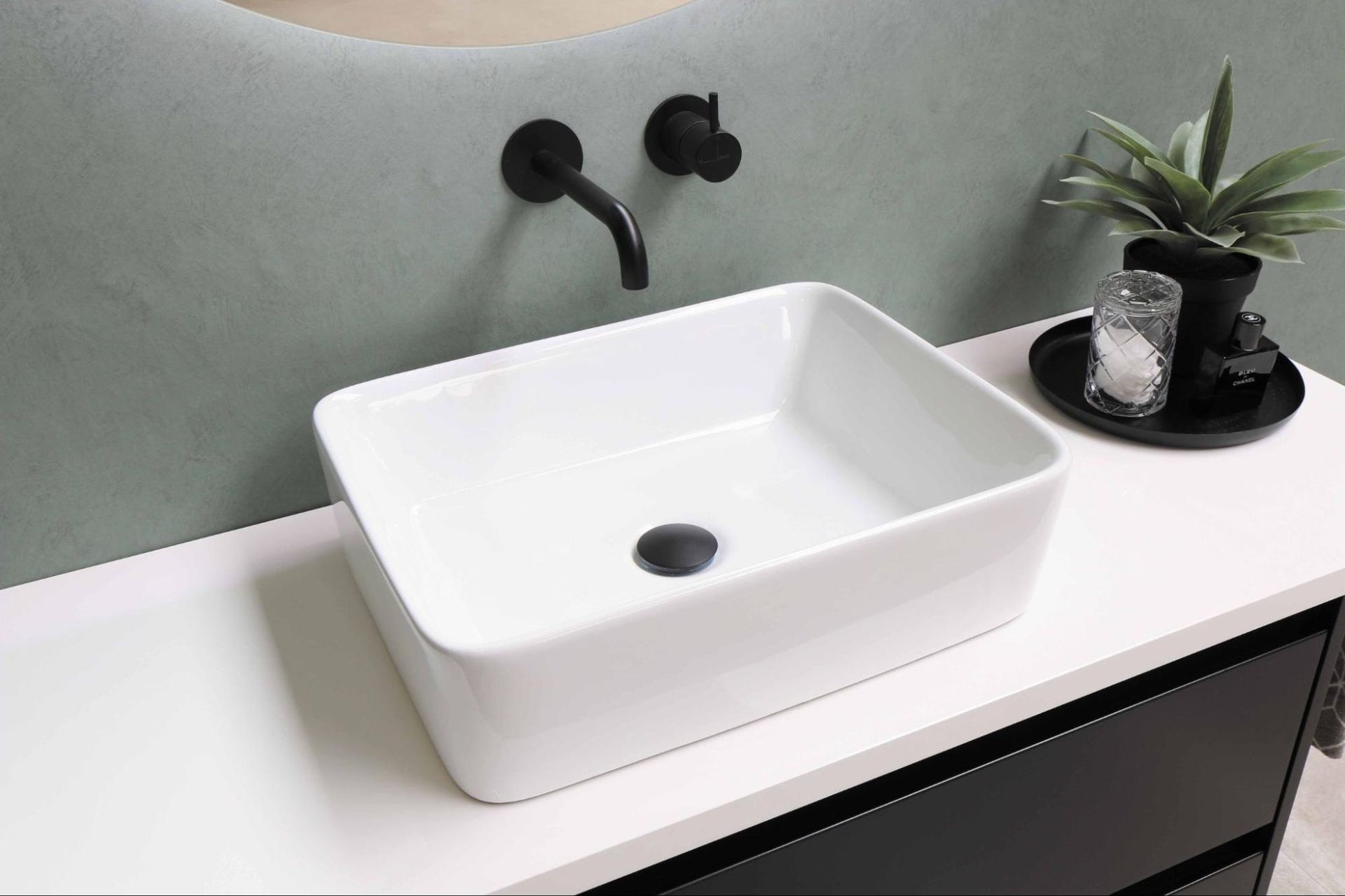 A white sink is sitting on top of a white counter in a bathroom.