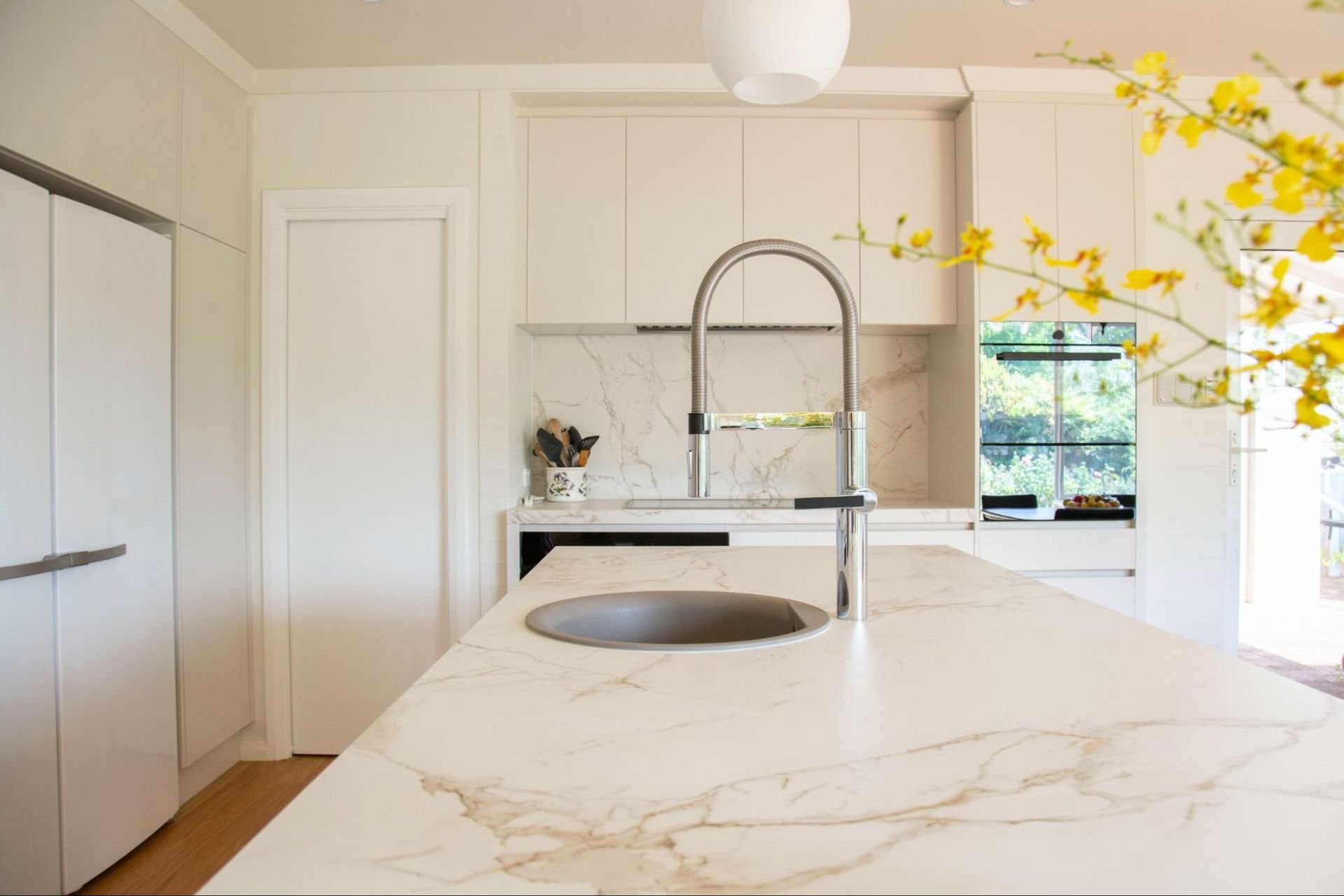A kitchen with a marble counter top and a sink.